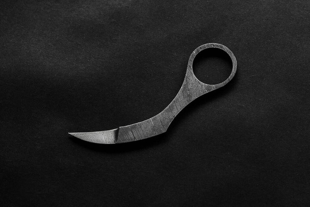 knife karambit in the form of a claw made of metal on a black background - Photo, Image