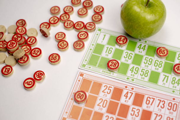 Houten vaten, kaarten en chips voor het spelen van lotto op een witte achtergrond - Foto, afbeelding