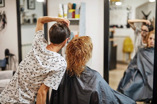 Hair dresser cutting hair in a saloon. - Photo, Image
