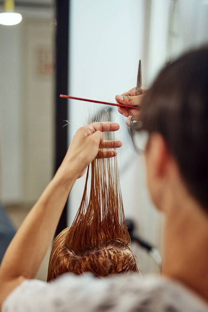 Κομμωτήριο κόβει τα μαλλιά σε ένα σαλούν. - Φωτογραφία, εικόνα