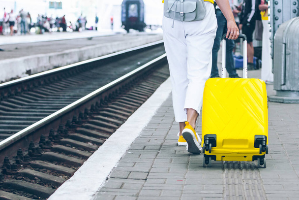 γυναίκα με κίτρινο σάκο στο σιδηροδρομικό σταθμό αντίγραφο χώρου - Φωτογραφία, εικόνα