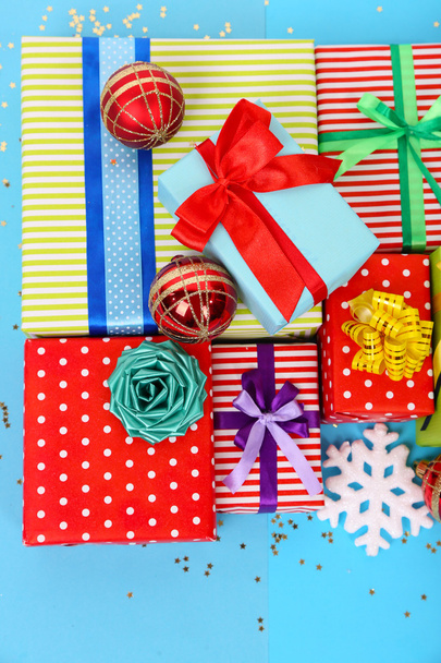 Many colorful presents with luxury ribbons on color background - Foto, imagen