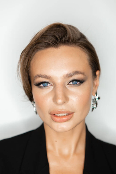 Portret van een mooie vrouw met make-up en styling. Blauwe ogen, modieuze wenkbrauwen en mooie lippen. - Foto, afbeelding