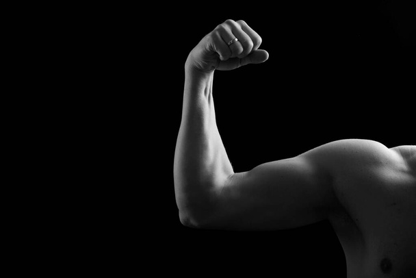 Bisturi muscular sobre fundo preto. Fotografia de estúdio do bíceps humano. Corpo masculino sexy. Mão humana
. - Foto, Imagem