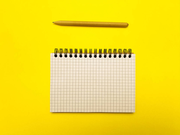 Bloc de notas para escribir sobre un fondo amarillo
 - Foto, imagen