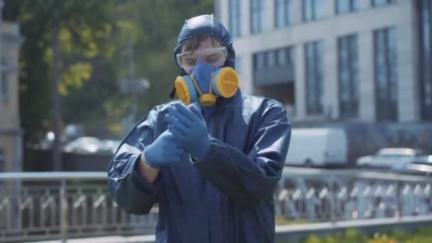 Joyful young man taking off gloves and respirator and making victory gesture. Portrait of happy Caucasian guy inhaling fresh air after Covid-19 isolation. Pandemic lifestyle, coronavirus lockdown. - Video, Çekim