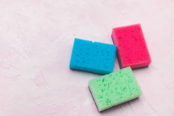 Multi colored household sponges. Pink background. - Fotó, kép