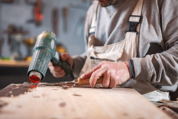 Menuisier homme travaillant sur du vieux bois dans un atelier vintage rétro. - Photo, image