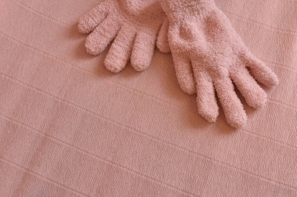 рожеві зимові рукавички на рожевому фоні
 - Фото, зображення