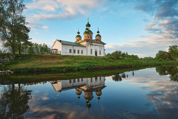 Ortodoks Kilisesi ile yaz manzarası ve nehirdeki bulutların yansıması.. - Fotoğraf, Görsel