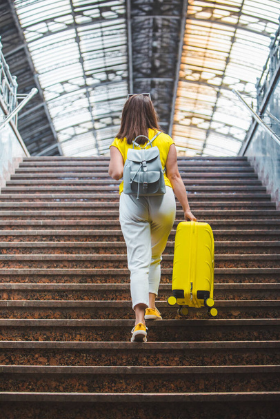 femme avec sac jaune montant par les escaliers à la gare concept de voyage
 - Photo, image
