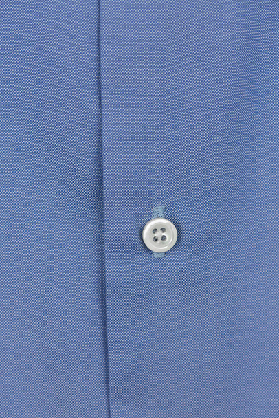 Fehér gomb egy klasszikus kék ingen. makró fotó. Ruhát adni egy üzletembernek. pamut férfi ing közelről - Fotó, kép