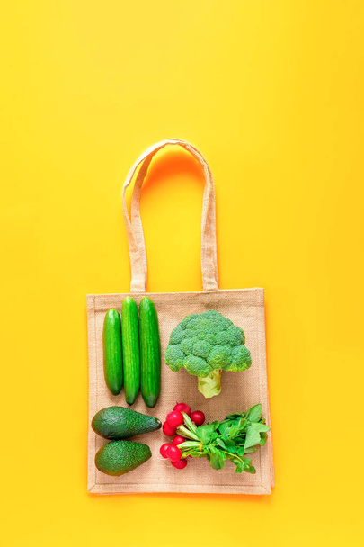 Semmi pazarlás. Környezetbarát természetes textil táska zöldséggel sárga alapon. Felülnézet, lapos fektetés - Fotó, kép