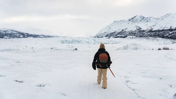 Mutige Wanderer beim Trekking im Schnee am Matanuska-Gletscher in Alaska. Er folgt einem Pfad zu den Eishöhlen. Extremes Abenteuer in den Winterferien. Spaß in den Bergen. Panorama, filmisch - Foto, Bild