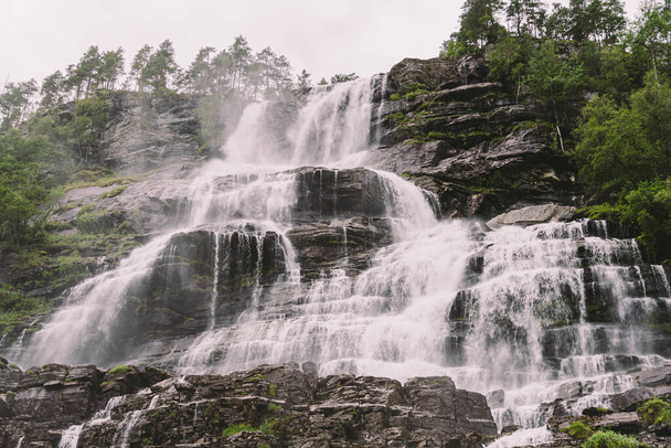 pohled na Tvindefossen nebo Tvinnefossen vodopád u Voss, Norsko. Přírodní krajina. Tvinde Camping. Marquee, rock - Fotografie, Obrázek
