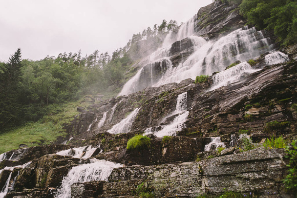 pohled na Tvindefossen nebo Tvinnefossen vodopád u Voss, Norsko. Přírodní krajina. Tvinde Camping. Marquee, rock - Fotografie, Obrázek