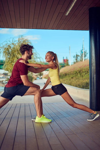 Modern woman and man jogging / exercising in urban surroundings near the river. - Φωτογραφία, εικόνα
