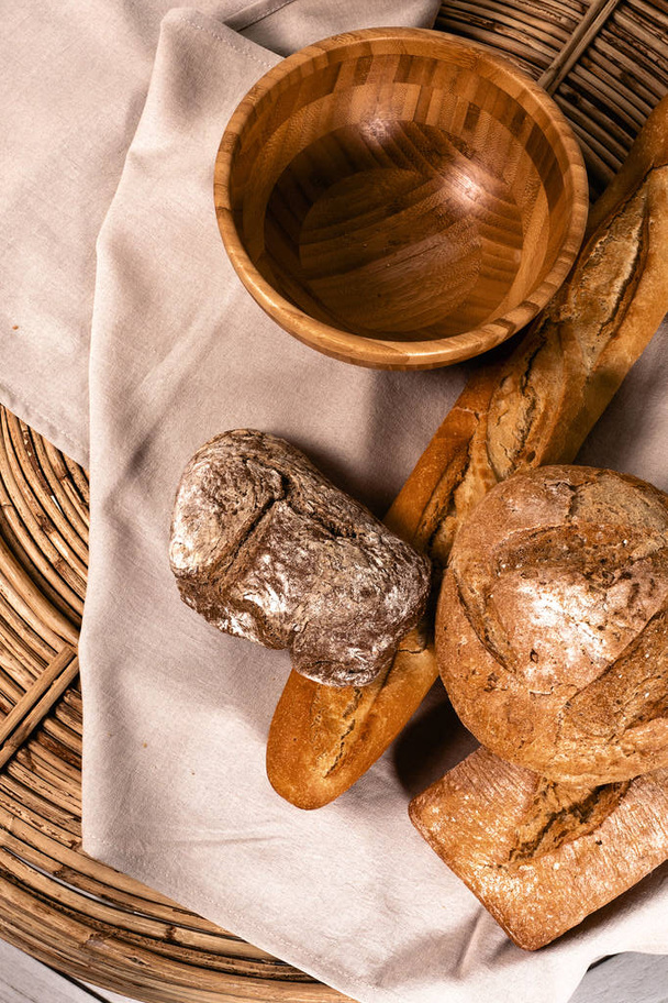crujiente, pan recién horneado. Placa de madera. textiles. la cesta de paja. panadería
 - Foto, imagen