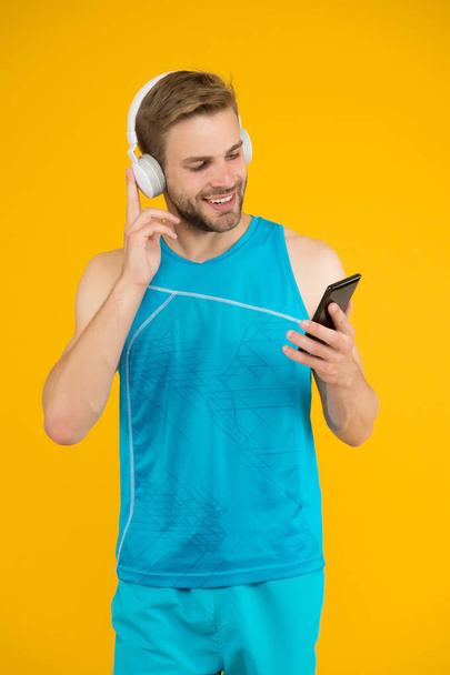 Athletic man listen music smartphone. Workout playlist. Sport and fitness. Active lifestyle. Health and wellness. Workout motivation. Tracking progress. Application for trainings with online couch - Φωτογραφία, εικόνα