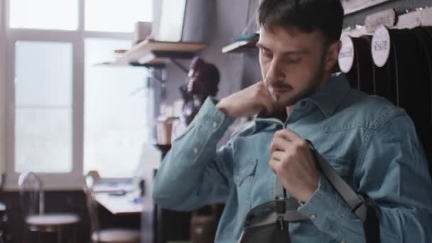 Jóképű férfi cserző kötényt visel - Felvétel, videó