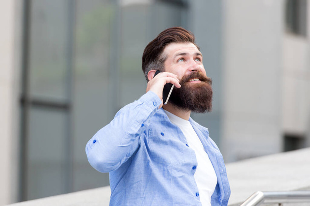Handsome man with bristle outdoors. Mobile communication. Business conversation. Man with smartphone. Man wearing casual shirt hold smartphone. Modern life. Agile business. Thanks. How are you doing - Фото, изображение