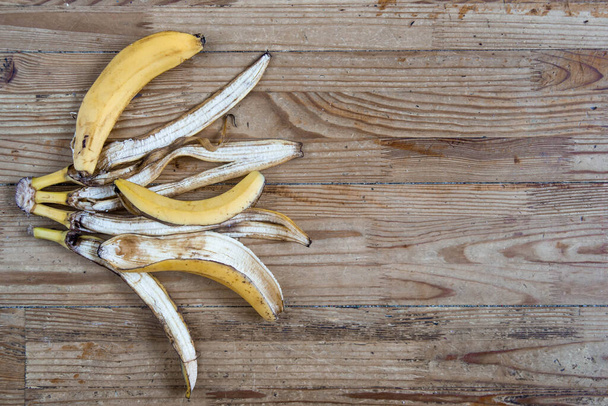 Éplucher la banane à plat sur un vieux fond en bois. Concept de tri des déchets organiques
 - Photo, image
