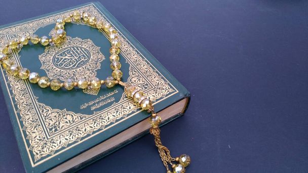 Sagrado Corán y rosario sobre fondo negro aislado. Concepto de Ramadán
 - Foto, imagen