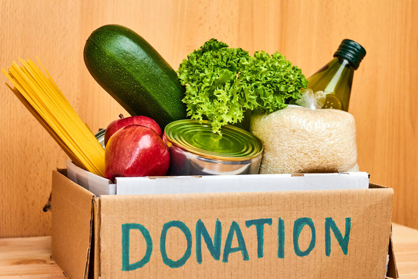 Пожертвования картонная коробка с различными продуктами питания, овощи, фрукты, крупы, масло и консервы. Концепция благотворительности или доставки
.  - Фото, изображение