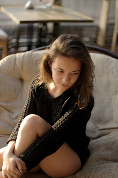 portrait of young girl in black jacket sweater at sunset, summer interior - Photo, Image