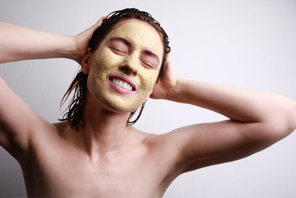 Happy woman with moisturizing facial mask with closed eyes isolated on grey background. Beauty and skin care. - Fotoğraf, Görsel
