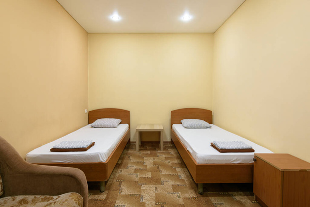 L'intérieur d'une chambre d'hôtel économique avec deux lits
 - Photo, image