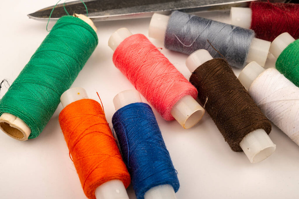 Diversi rulli di filo da cucire multicolore su uno sfondo bianco. Da vicino.
 - Foto, immagini