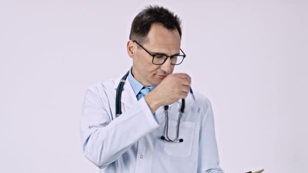 Caucasian doctor takes pen from his breast pocket and takes notes on the tablet. - Footage, Video