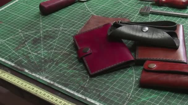 Acabado carteras de cuero hechas a mano llaveros en la mesa de curtidores
 - Metraje, vídeo