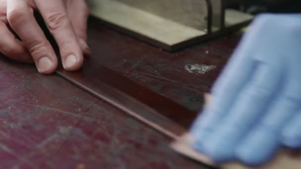 O bronzeador profissional está a afiar um cinto. O mestre de couro está fazendo um cinto
 - Filmagem, Vídeo