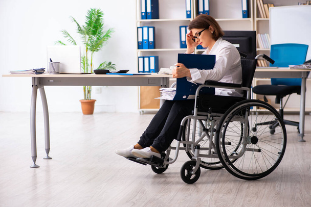 Γυναίκα υπάλληλος σε αναπηρική καρέκλα στο γραφείο - Φωτογραφία, εικόνα