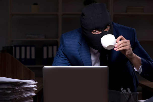 Homem empregado roubando informações no escritório noite tempo
 - Foto, Imagem