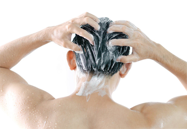 Κοντινό πλάνο νεαρός άνδρας που πλένει τα μαλλιά με σαμπουάν ισοπεδωμένο σε λευκό φόντο - Φωτογραφία, εικόνα