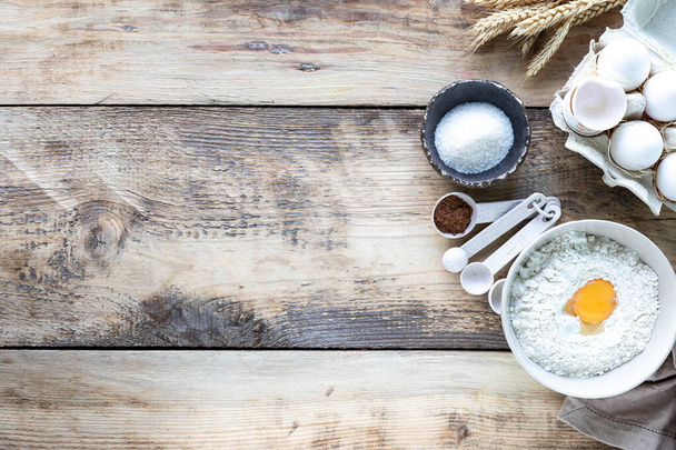 Ingrediënten voor het bakken Kleine pannenkoekencornflakes op een houten achtergrond bovenaanzicht. Recept. Plaats voor tekst. - Foto, afbeelding