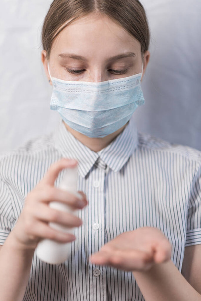 teenager girl in medical mask, antiseptic spray bottle, hand from bacteria, prevention of virus infection safety, carefully flu disease, stay home, stop pandemic of coronovirus covid 19 - Zdjęcie, obraz