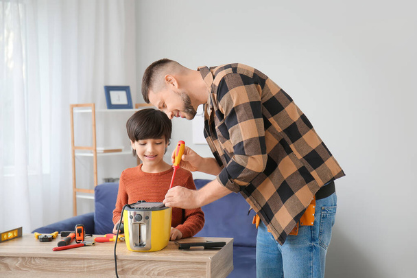 Otec a malý syn doma opravují toustovač - Fotografie, Obrázek