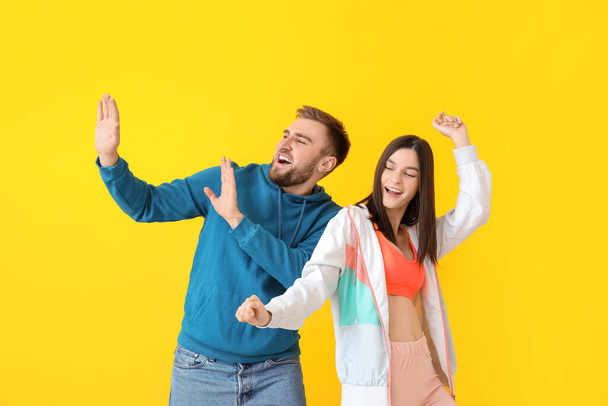 Glückliches junges Paar tanzt vor farbigem Hintergrund - Foto, Bild