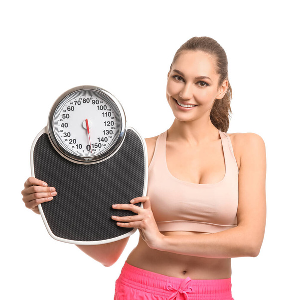 Young woman with weight scales on white background - Foto, imagen