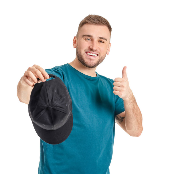 Hombre guapo con elegante gorra que muestra el pulgar hacia arriba sobre fondo blanco
 - Foto, Imagen