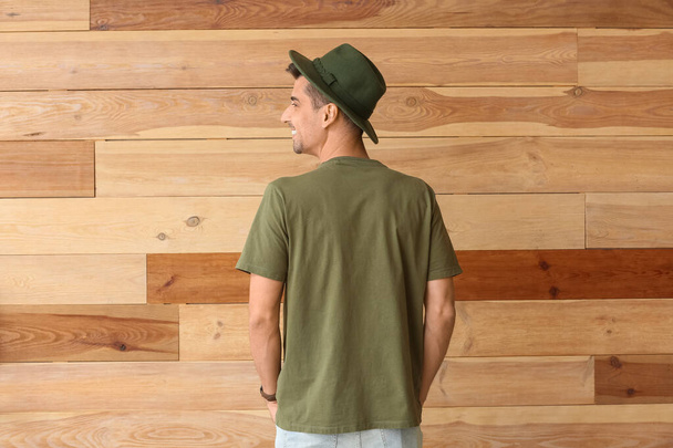 Man in stylish t-shirt on wooden background - Zdjęcie, obraz