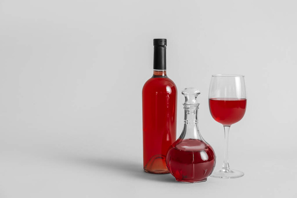 Decantador y botella de vino con copa sobre fondo gris
 - Foto, imagen