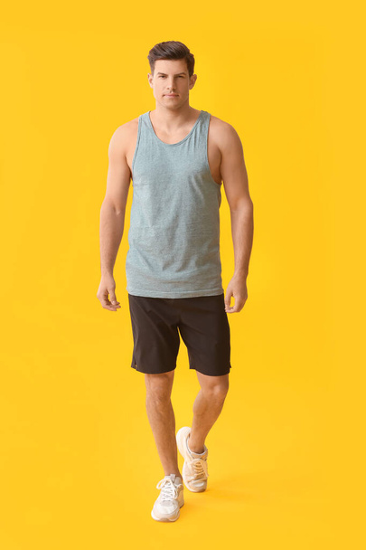 Sporty young man on color background - Фото, зображення