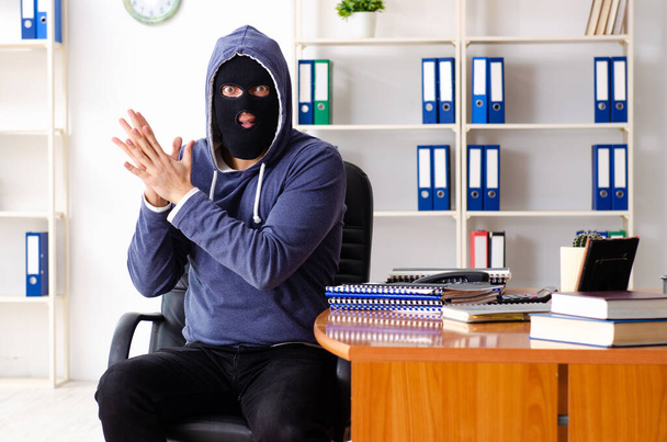 Férfi tolvaj maszkban az irodában. - Fotó, kép