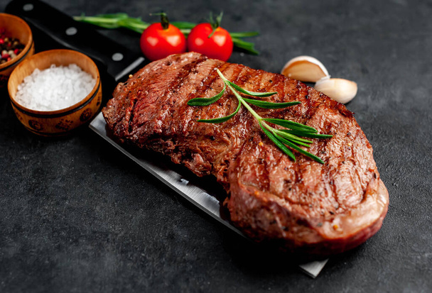 grilled beef steak with spices on a knife on a stone background - Фото, зображення