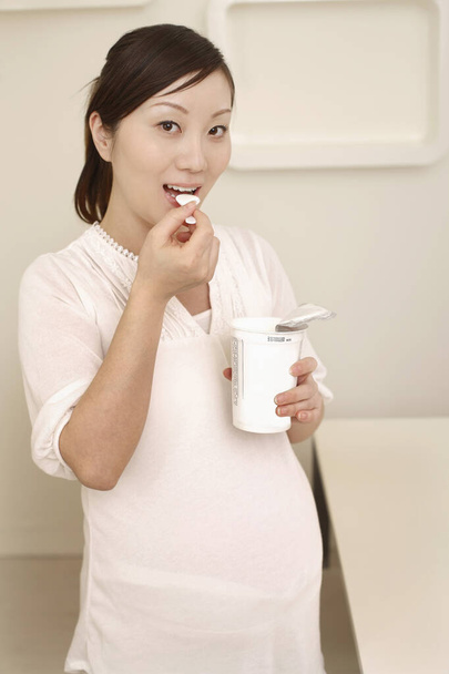 Pregnant woman eating yoghurt - Foto, Imagem